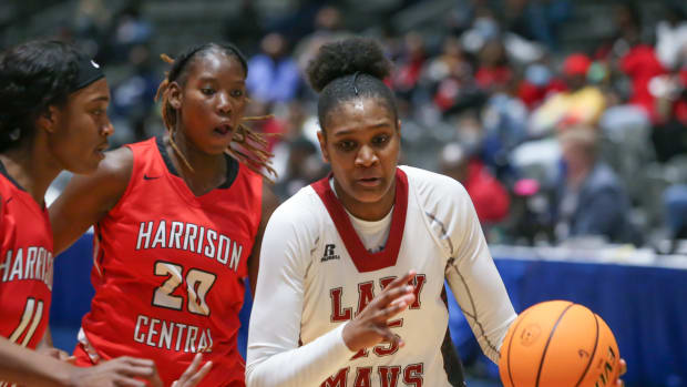 Germantown's Madison Booker (15) drives to the basket as Harrison Central's JeMya Evans (20) and Harrison Central's Dekeria Walls (11) defend. Germantown and Harrison Central played in an MHSAA Class 6A basketball semifinal basketball game at Mississippi Coliseum on Wednesday, March 3, 2020. Photo by Keith Warren